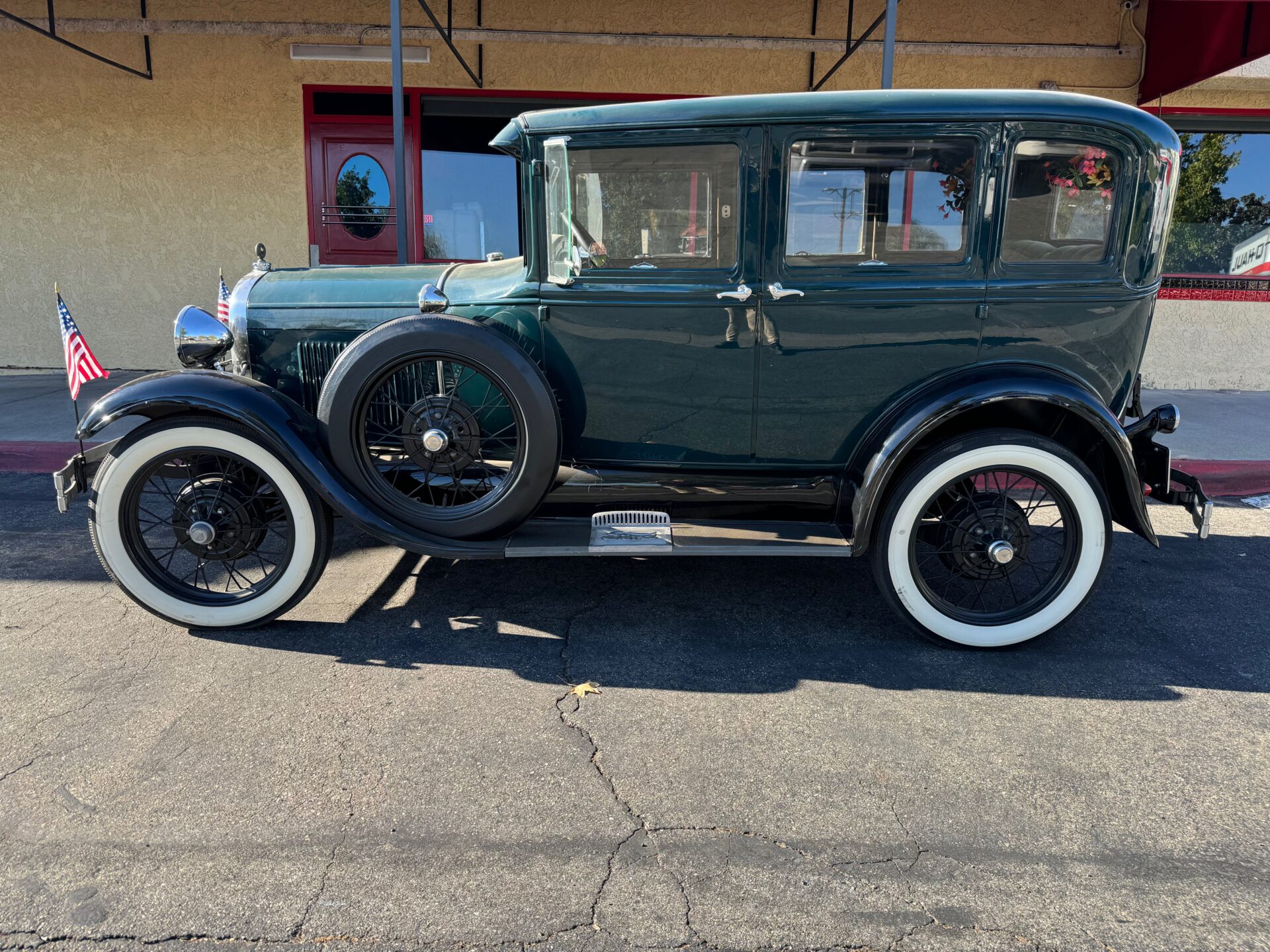 1929 Ford Model A Sedan | Temecula Auto Repair & Transmission A green Ford Model A Sedan parked in front of Temecula Auto Repair & Transmission, waiting for service.