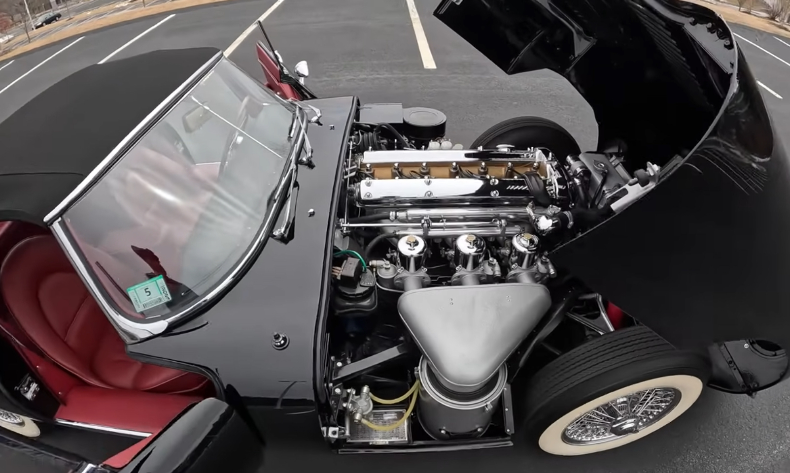 Jaguar E-Type Engine | Temecula Auto Repair & Transmission A black 1964 Jaguar E-Type with its hood open showing the engine.