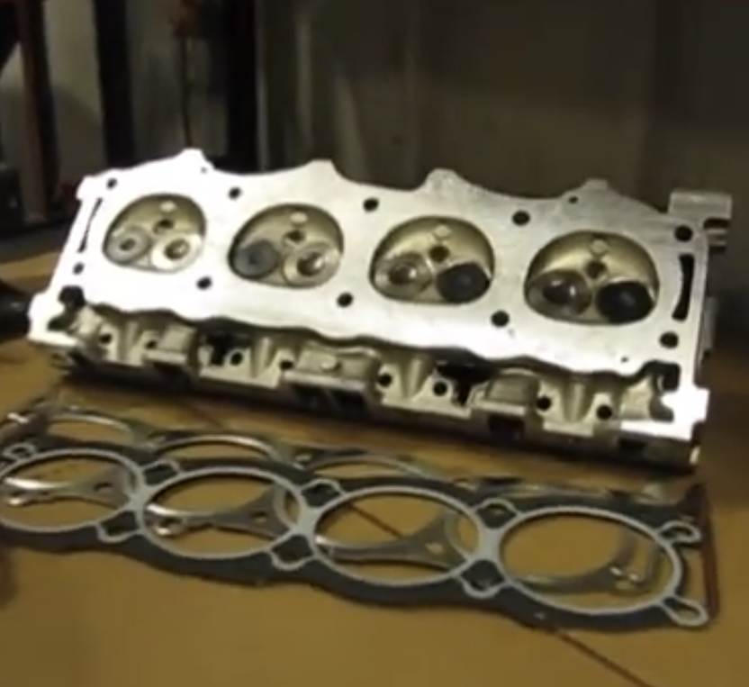 Land Rover Cylinder Head Gasket Replacement | Temecula Auto Repair & Transmission Land Rover Cylinder Head and Gasket on the workbench during Replacement.