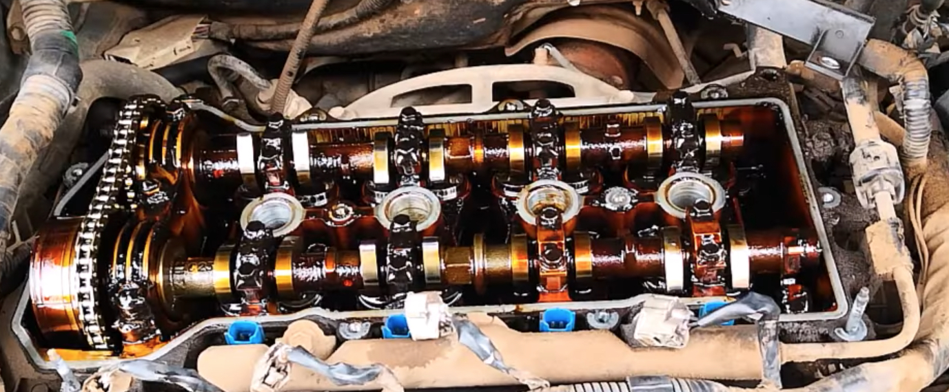 Oil Sludge | Temecula Auto Repair & Transmission Engine valve cover removed, exposing oil sludge deposits in the engine.