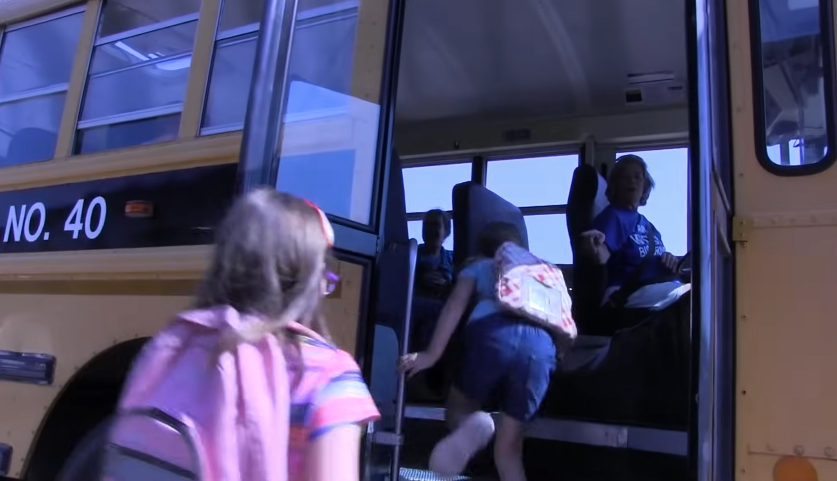 School Bus with Children Boarding | Temecula Auto Repair & Transmission A school bus stopped at a school bus stop, with children boarding.