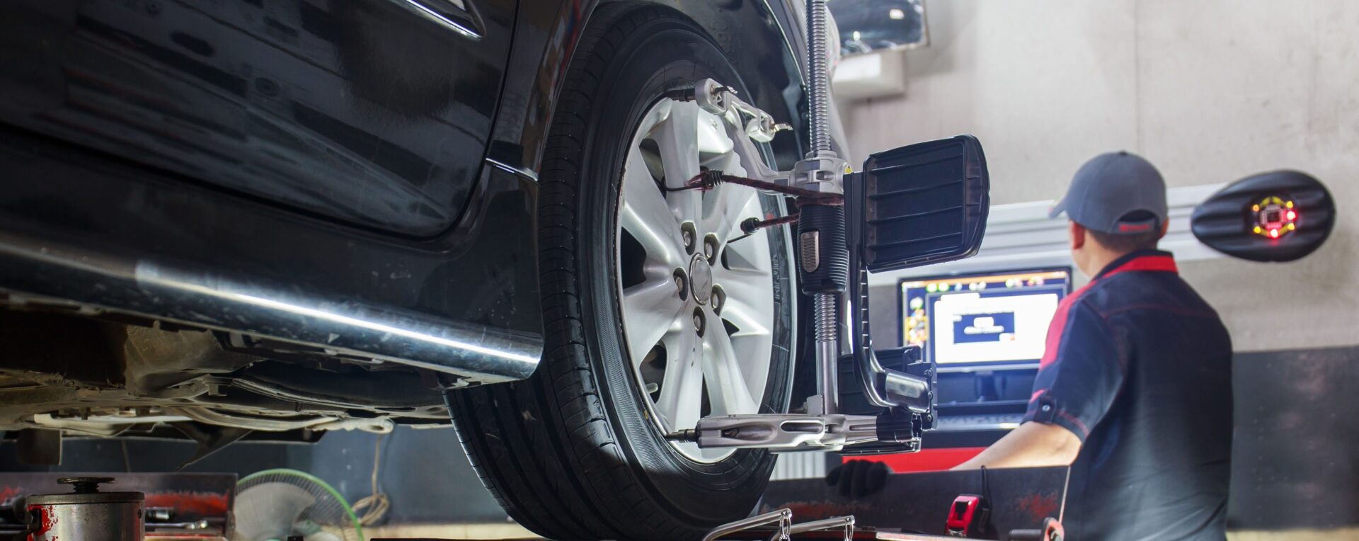 Wheel Alignment | Temecula Auto Repair & Transmission A technician performing a wheel alignment on a vehicle.